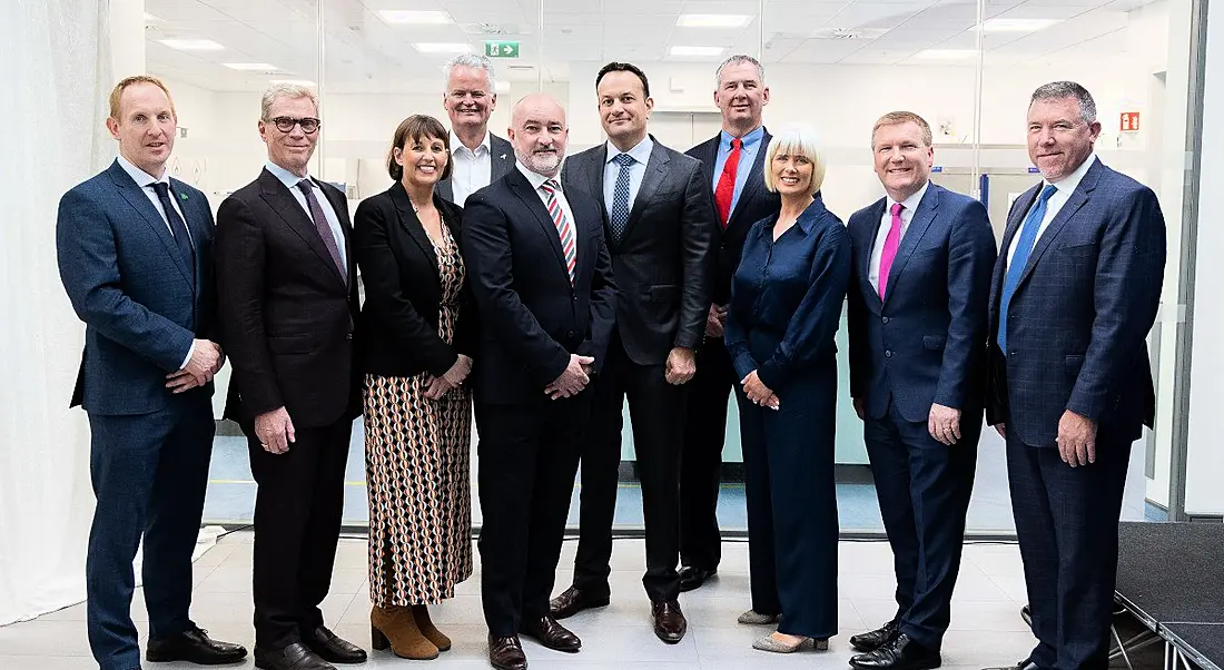 A group of ten people standing together in a bright white room at the opening of BioMarin Cork's new expansion.