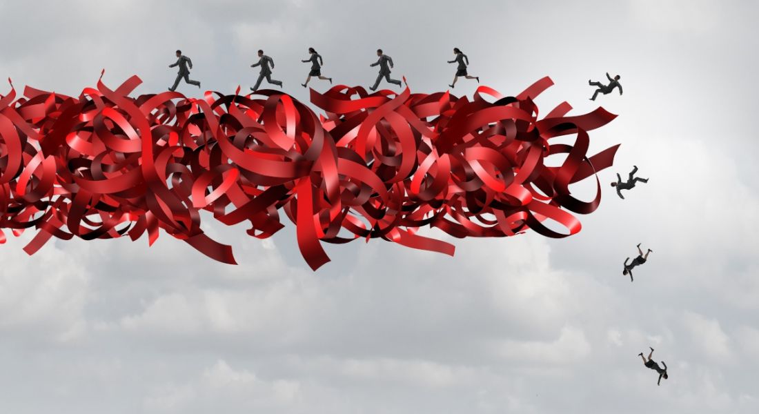 Bundles of red tape bound together in mid air with people in the distance running along them like they are a giant conveyor belt but failing to stay on.