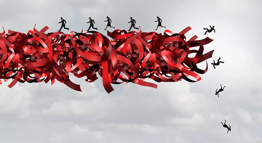 Bundles of red tape bound together in mid air with people in the distance running along them like they are a giant conveyor belt but failing to stay on.