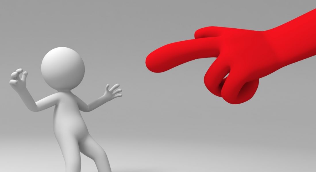 A red hand pointing at a figure which is leaning back as if stunned. Criticism concept.