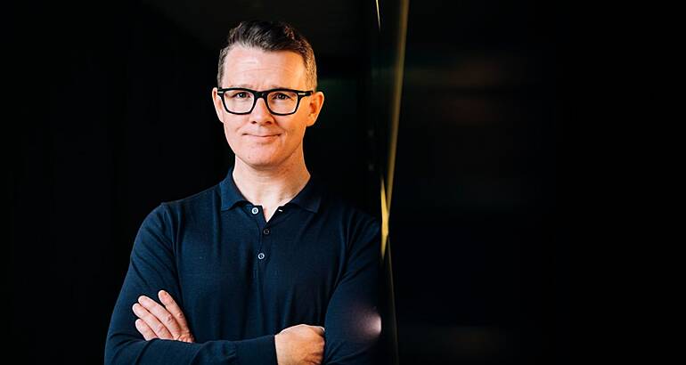 Eoin Leonard of Catalyst standing against a dark background.