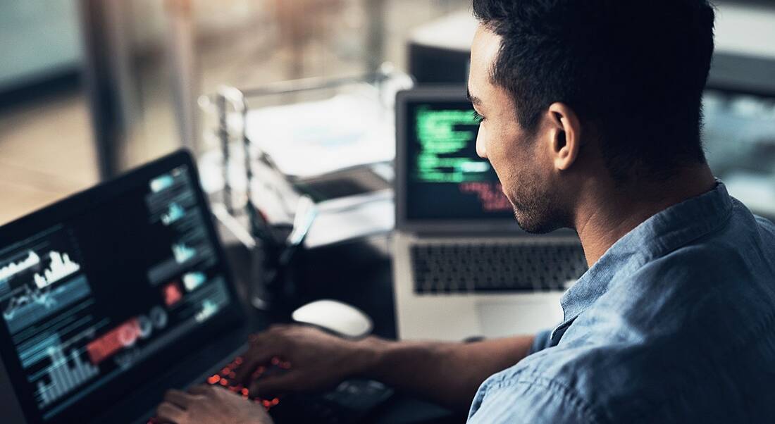 A man working at a screen, representing tech jobs and working in tech.