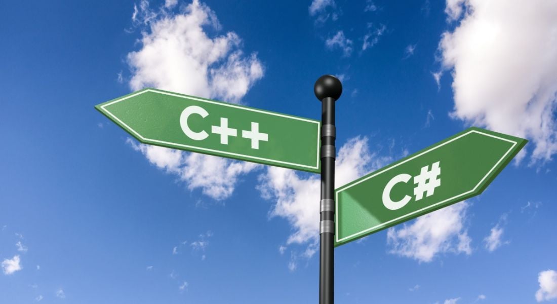 A pole with two diverging signs shaped like arrows with C++ and C# written on them. There is a blue sky and clouds in the background.