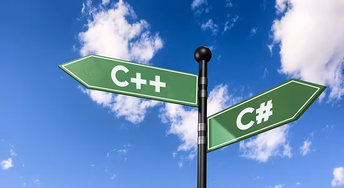 A pole with two diverging signs shaped like arrows with C++ and C# written on them. There is a blue sky and clouds in the background.