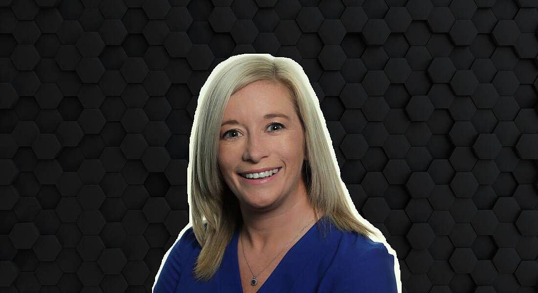 A woman with blonde hair smiles at the camera wearing a blue blouse. She is Kate Feeney, a senior manager at Fidelity Investments.