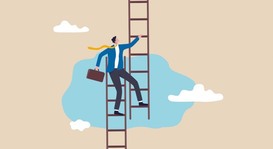 A person stands on the top of one ladder while stepping onto a different one, symbolising a career pivot.