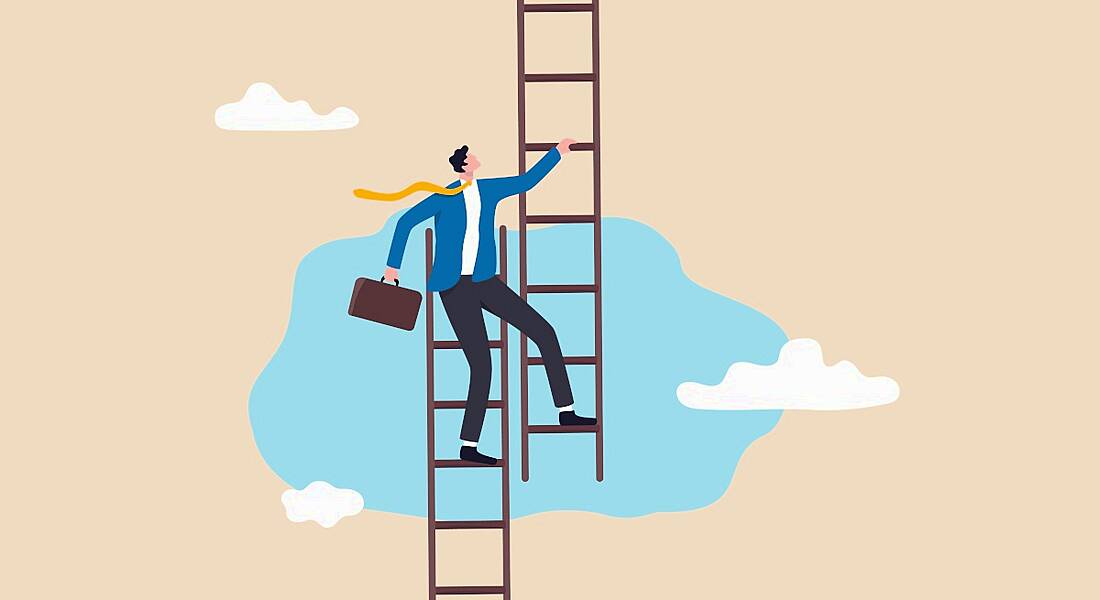 A person stands on the top of one ladder while stepping onto a different one, symbolising a career pivot.