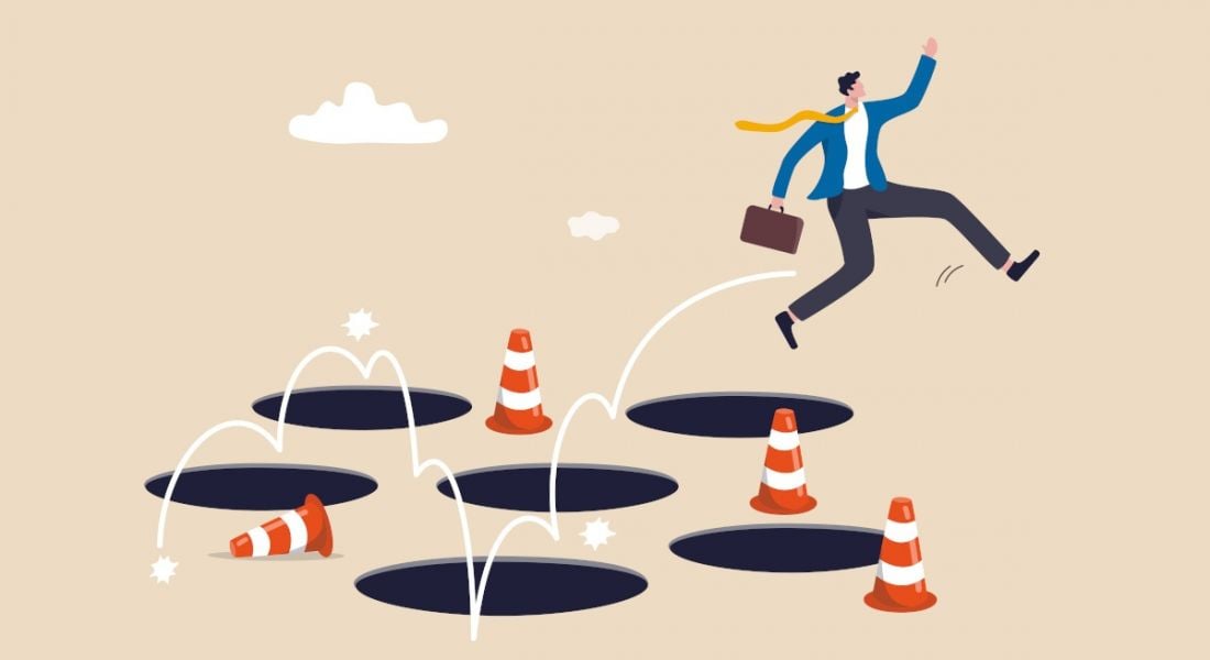 A cartoon of a man jumping around holes and orange cones, symbolising mistakes made by jobseekers.