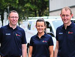 Martin Shanahan, Cecilia Ronan and Paschal Donohoe stand in an office space in front of a wall with the Citi logo on it.