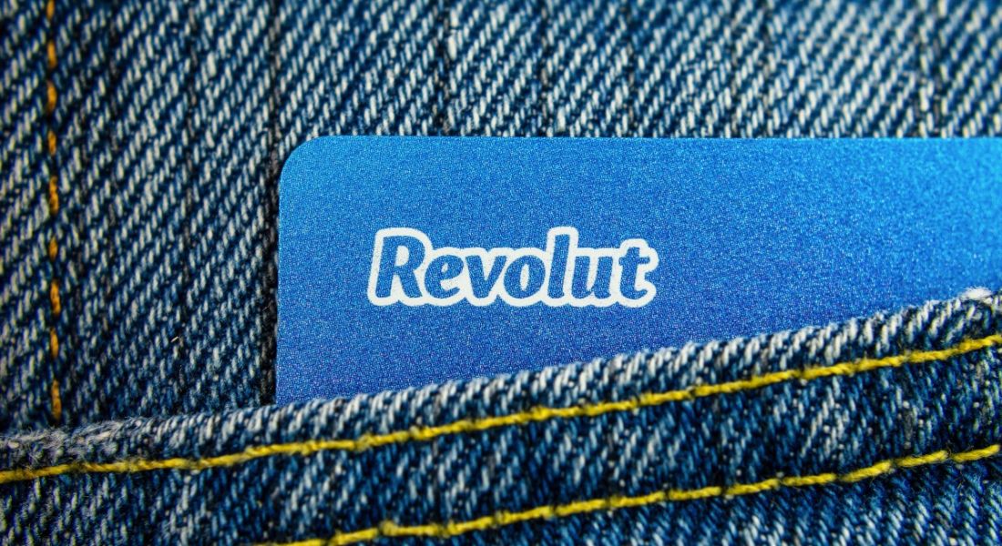 A close-up of a pocket on a pair of blue jeans with a blue Revolut card sticking out.