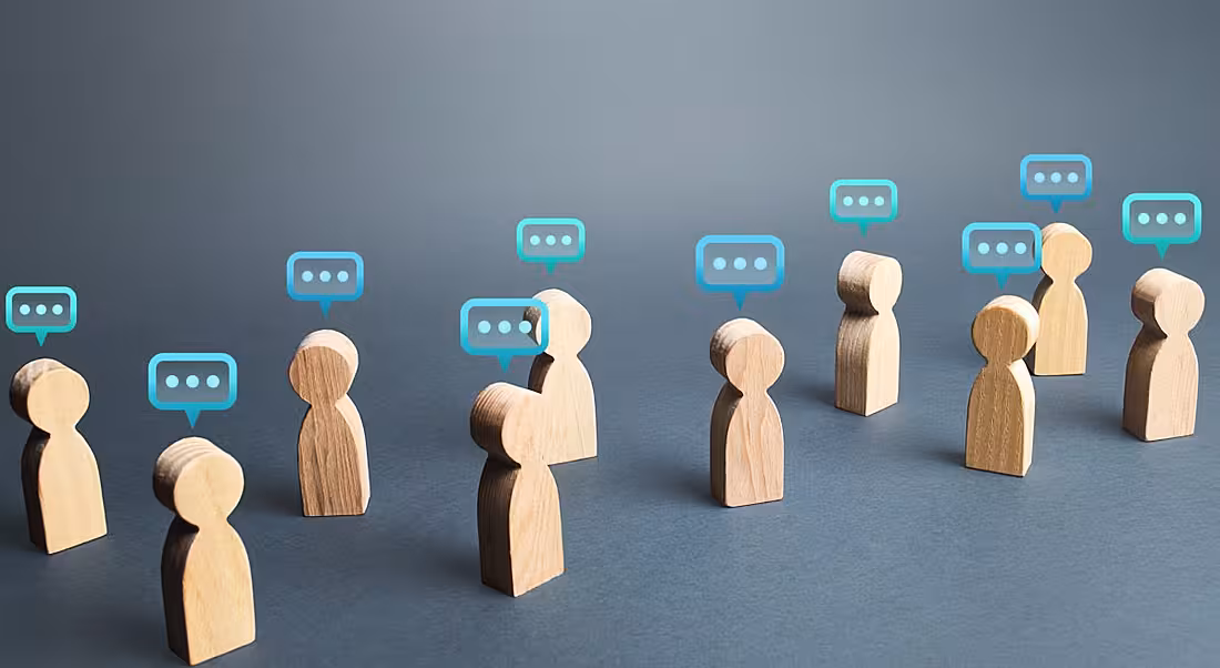 Wooden person shaped figures with speech bubbles over their heads.