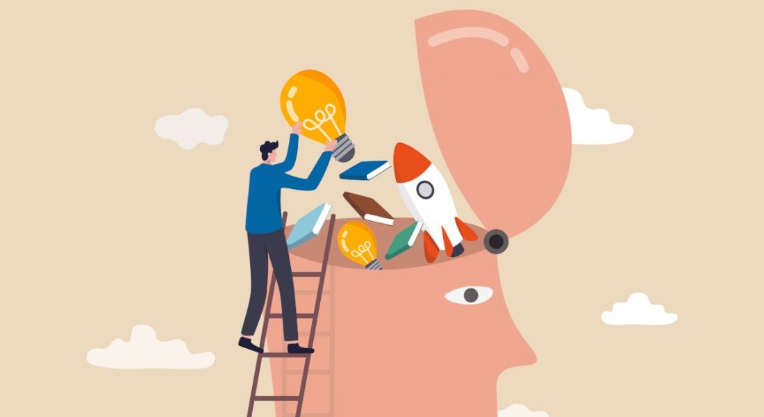 Cartoon showing a worker standing on a ladder throwing books and a rocket ship and other skills-related icons into a large head with its skull opened up.