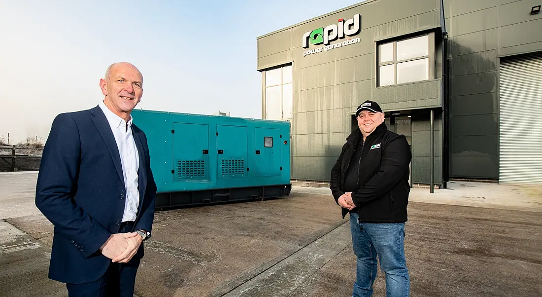 Two men standing at a slight distance from each other outside the Rapid Power Generation manufacturing facility in Armagh.