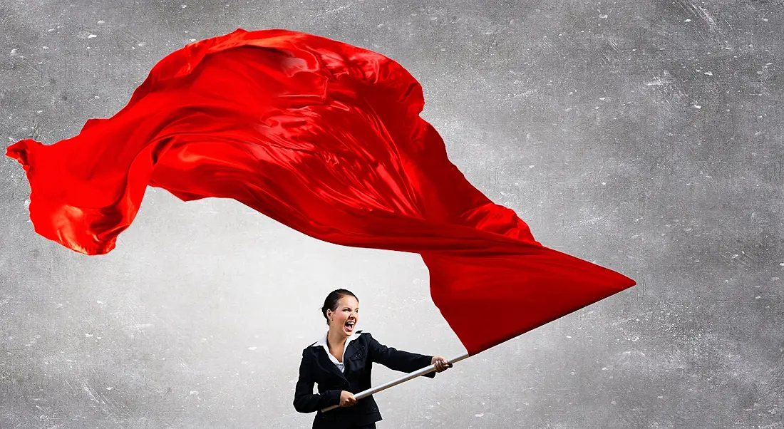 A businesswoman waving a huge red flag.