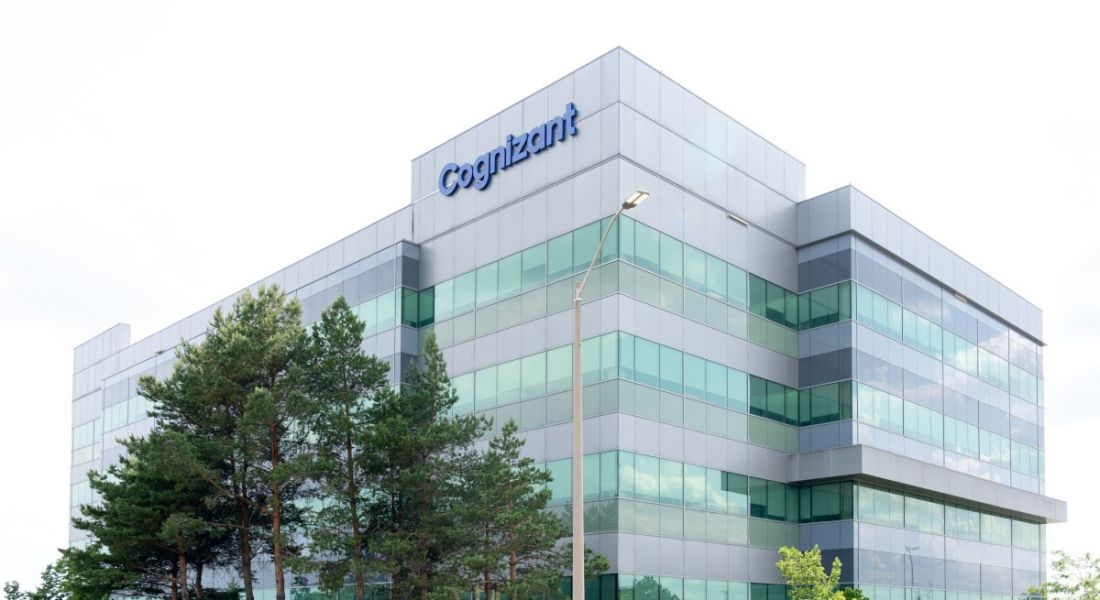 A tall building with the Cognizant logo on top, with a grey sky in the background.