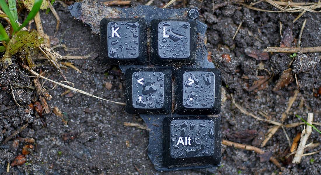 Keys from a broken computer lying on the damp ground.