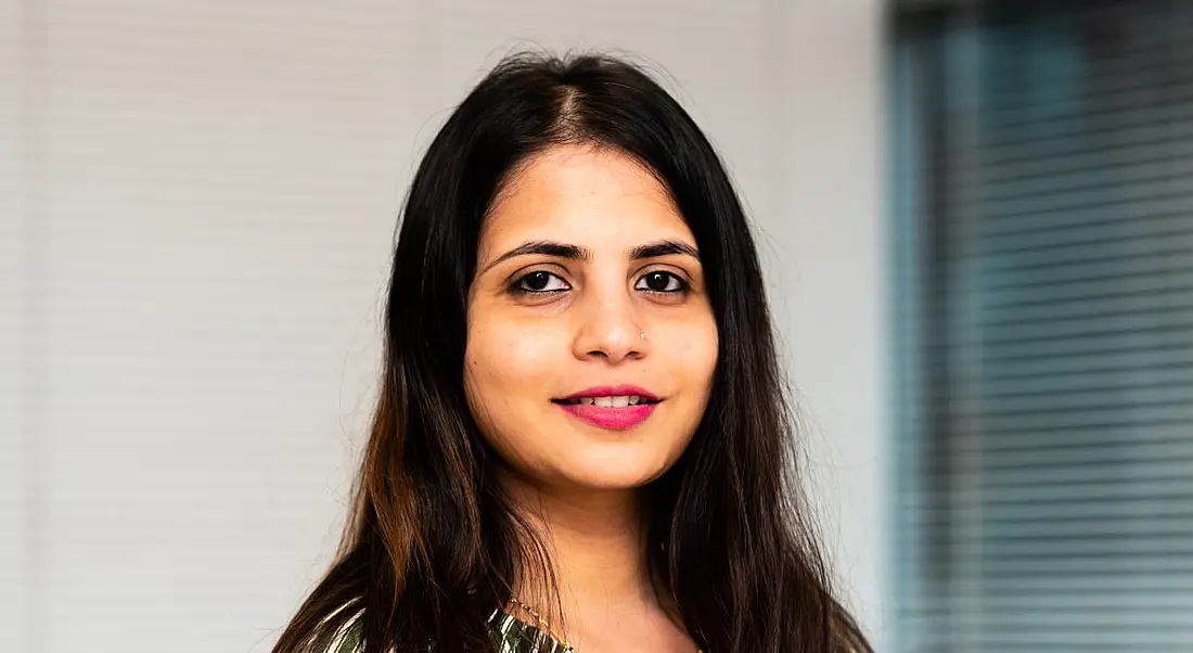 A woman stands smiling at the camera. She is Sonam Chougule, a senior data consultant at BearingPoint Ireland.