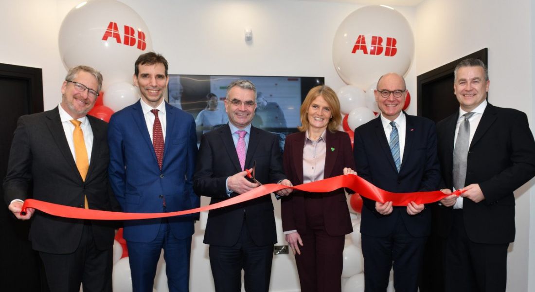 Six people standing in a row holding a ribbon at the opening of ABB's new R&D centre in Dundalk.