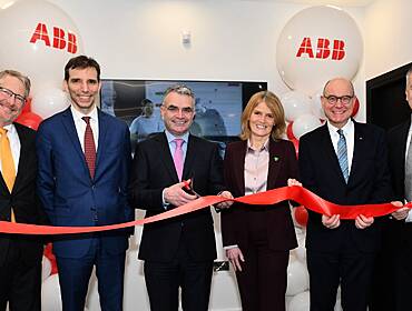 Six people standing in a row holding a ribbon at the opening of ABB's new R&D centre in Dundalk.