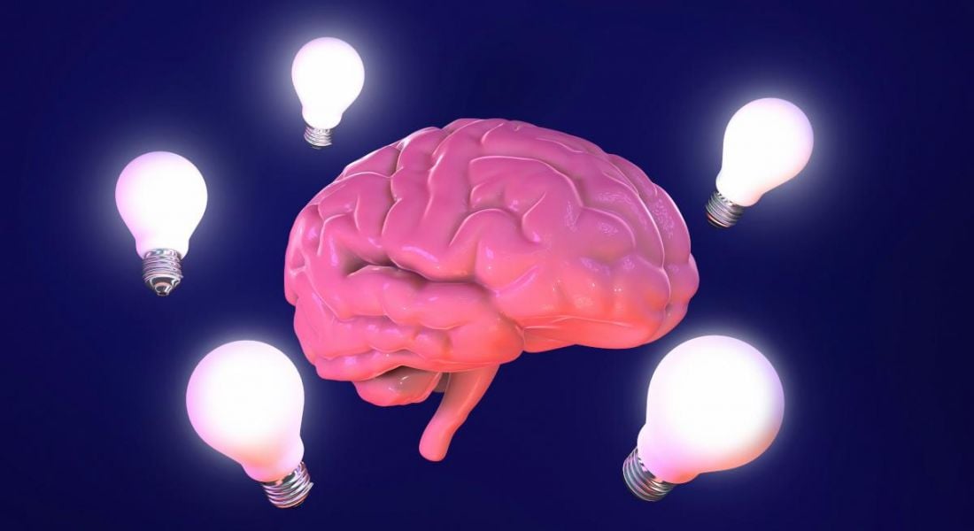 Neuroproductivity concept cartoon with pink brain surrounded by lightbulbs on a dark purple background.
