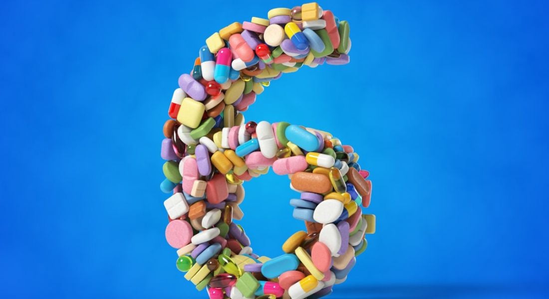 The number six made from different medicines and pills on a blue background.