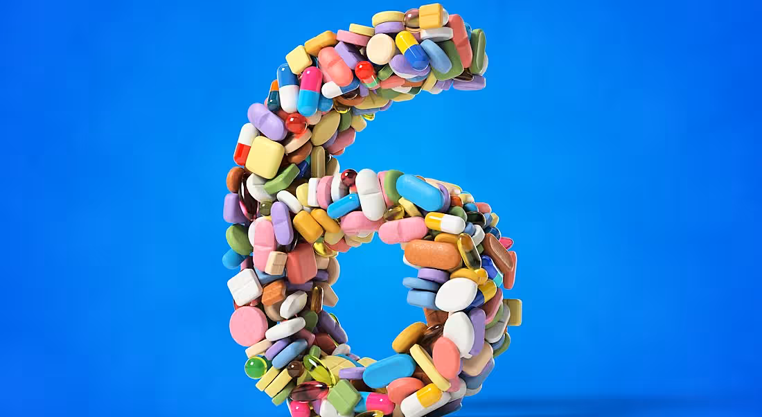 The number six made from different medicines and pills on a blue background.