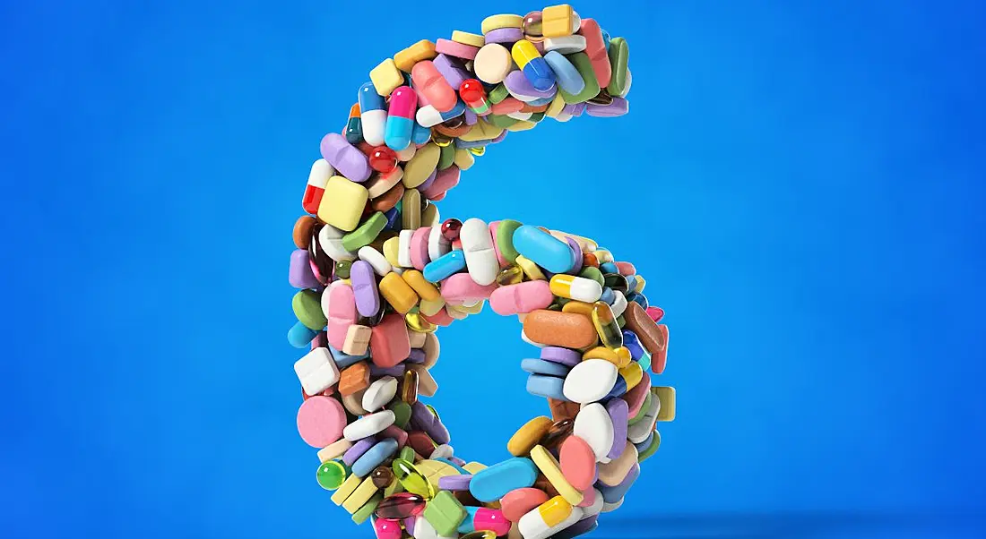 The number six made from different medicines and pills on a blue background.