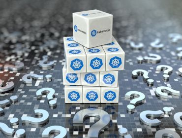 Stack of cubes with the Kubernetes logo on them resting on a grey surface with question marks littered around it.