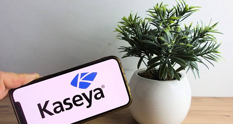 A phone with Kaseya branding on the screen with a potted plant beside it.