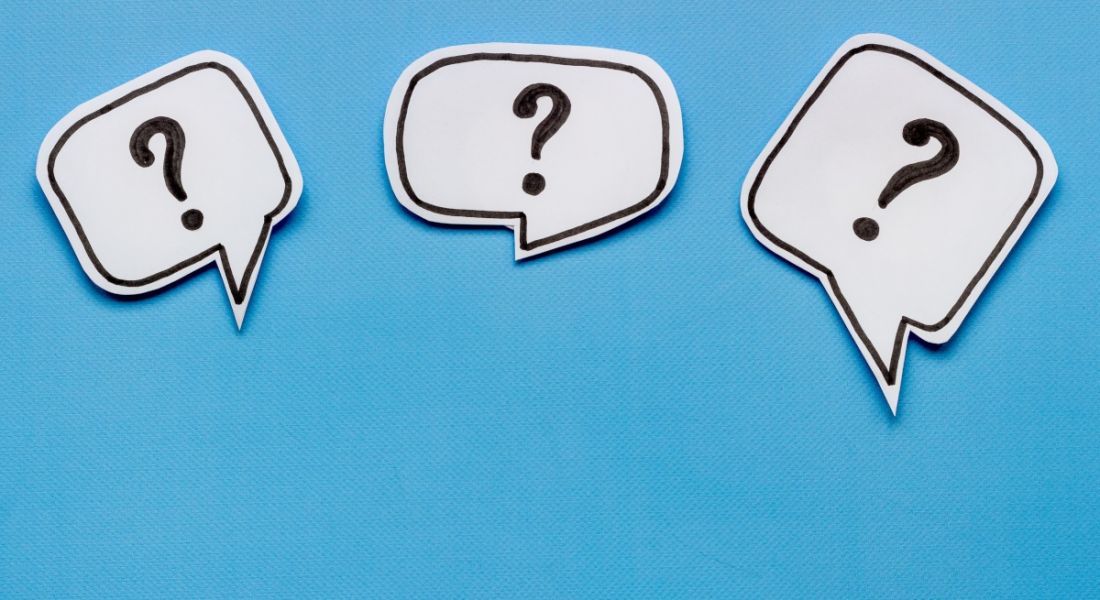Three black question marks in white speech bubbles floating on a blue background.
