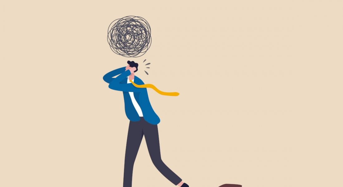 Cartoon of an anxious worker with a stress cloud over his head as he clutches his face in his hands.