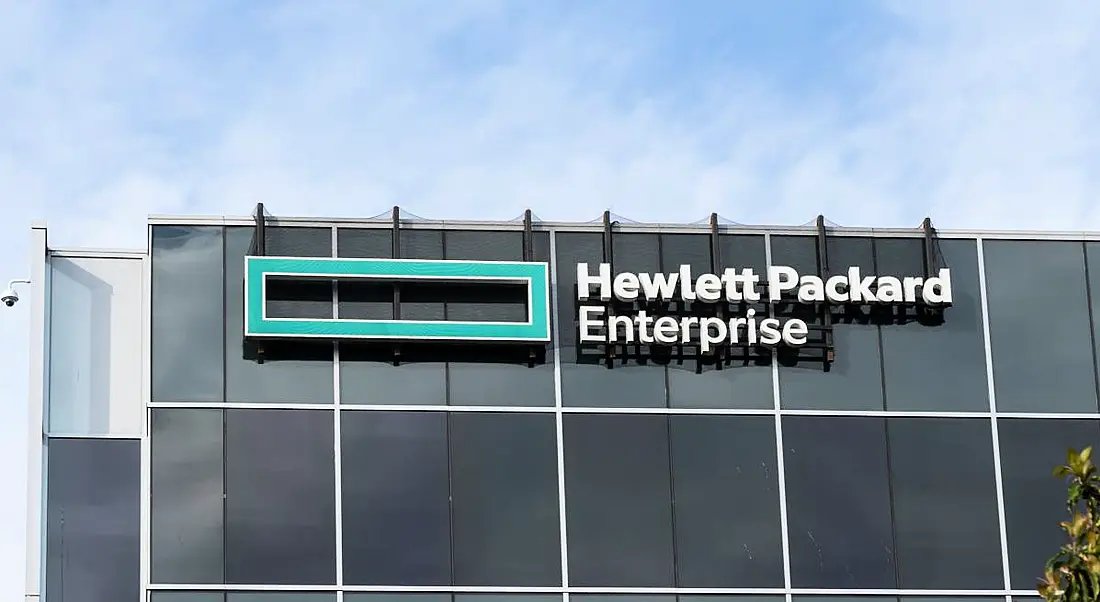 The outside of a large grey office building with HPE branding on it.