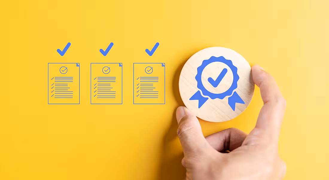 An image of three illustrated résumés with ticks above them. To the right of the illustrations is a person's hand placing a congratulatory ribbon.
