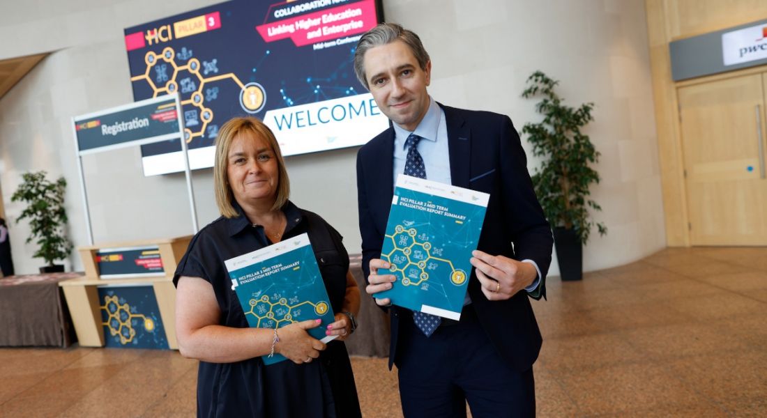 Dr Vivienne Patterson and Minister Simon Harris holding copies of a report.