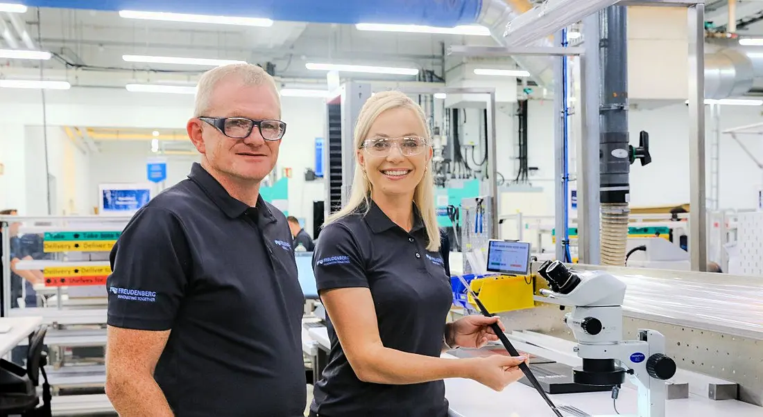 A man and a woman standing next to each other inside a manufacturing facility. They are part of Freudenberg Medical.