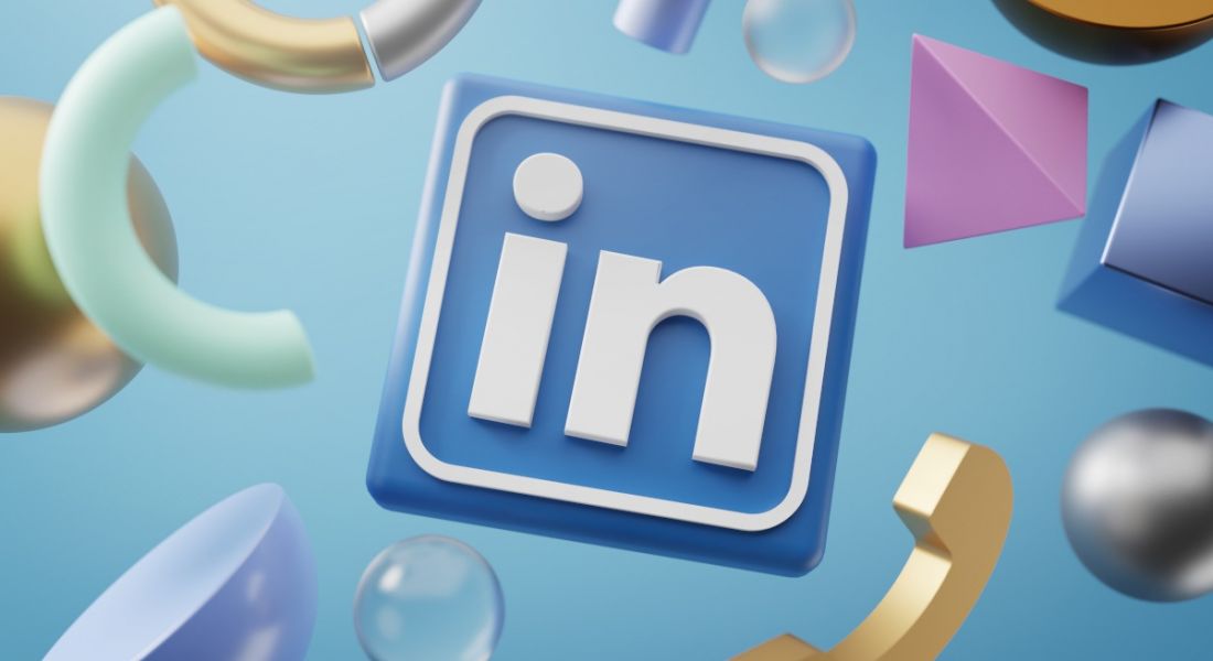 The LinkedIn logo on a light blue background with pastel shapes floating around it.
