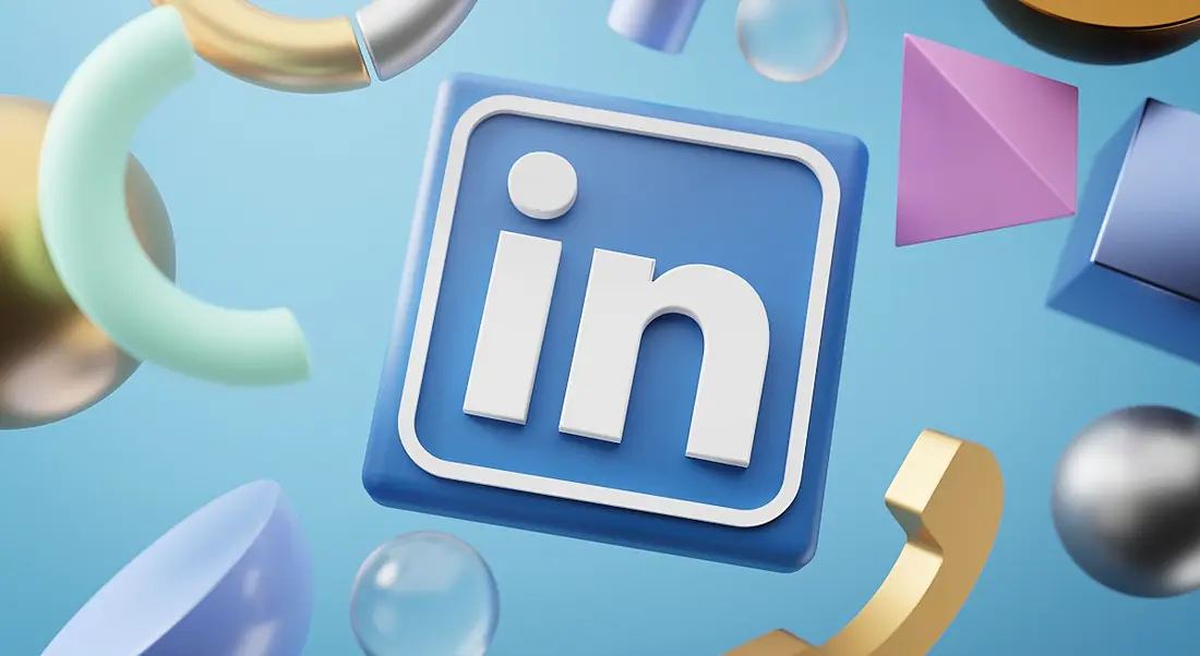 The LinkedIn logo on a light blue background with pastel shapes floating around it.