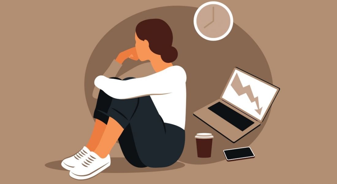 A cartoon showing a Gen Z worker suffering from burnout. She is facing away from her laptop, coffee and phone. The background is brown.