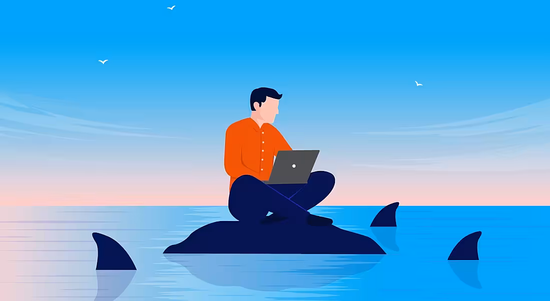 Cartoon of a worker as an insider threat sitting on a rock using a laptop as sharks representing cybercriminals circle around him.