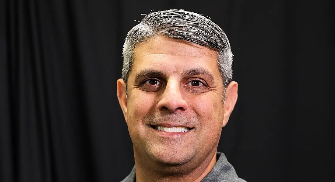 A close-up headshot of a man smiling at the camera. He is cybersecurity expert and Future Human podcast guest Neil Khatod.