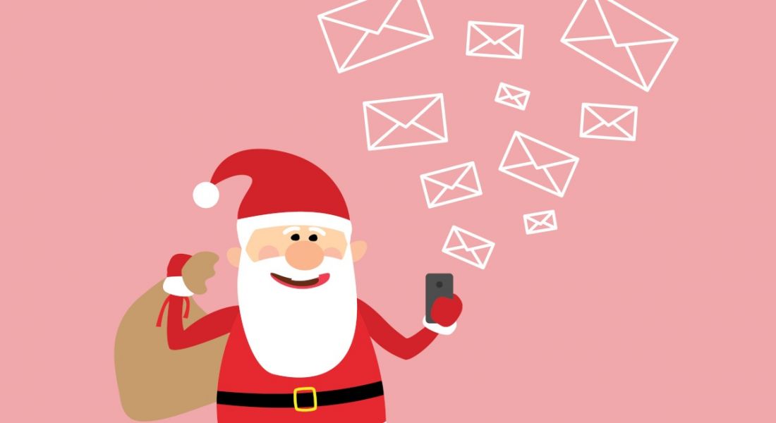 Cartoon of Santa Claus reading emails on his smartphone carrying a sack of presents. Pink background.