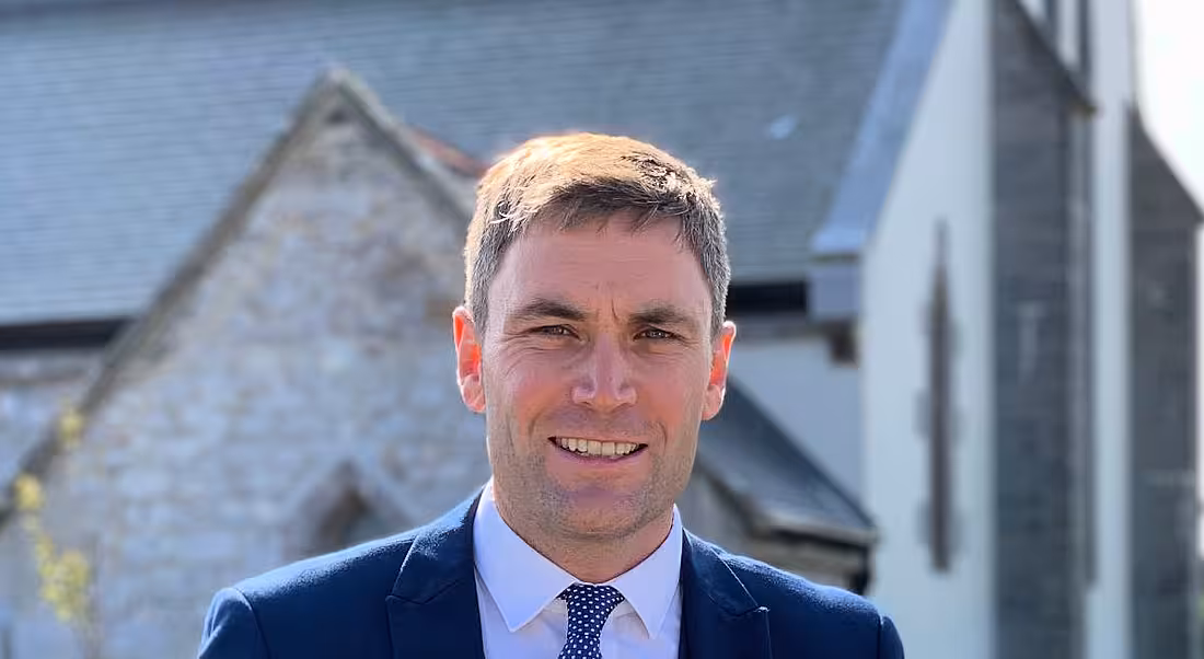 Harry O'Farrell with his head and shoulders visible in the frame and a grey building behind him.