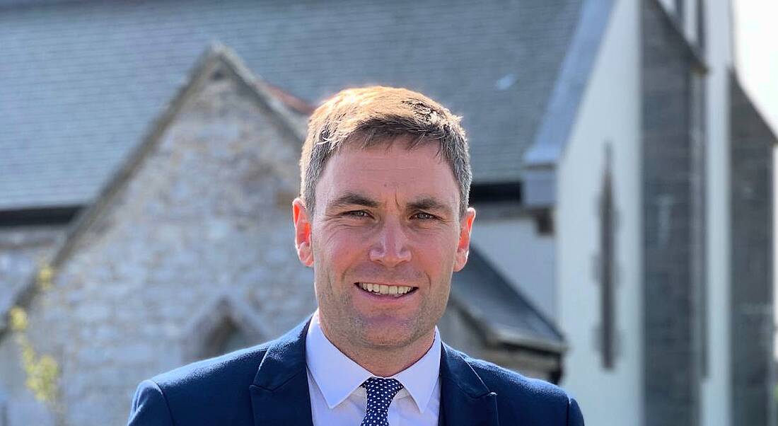 Harry O'Farrell with his head and shoulders visible in the frame and a grey building behind him.