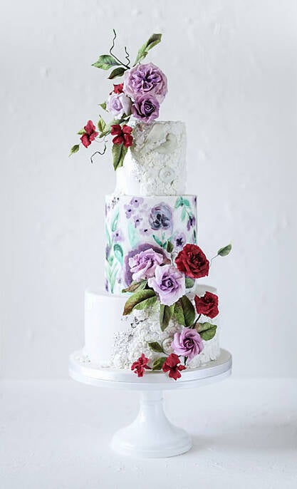 Three tier wedding cake with white icing and floral embellishments