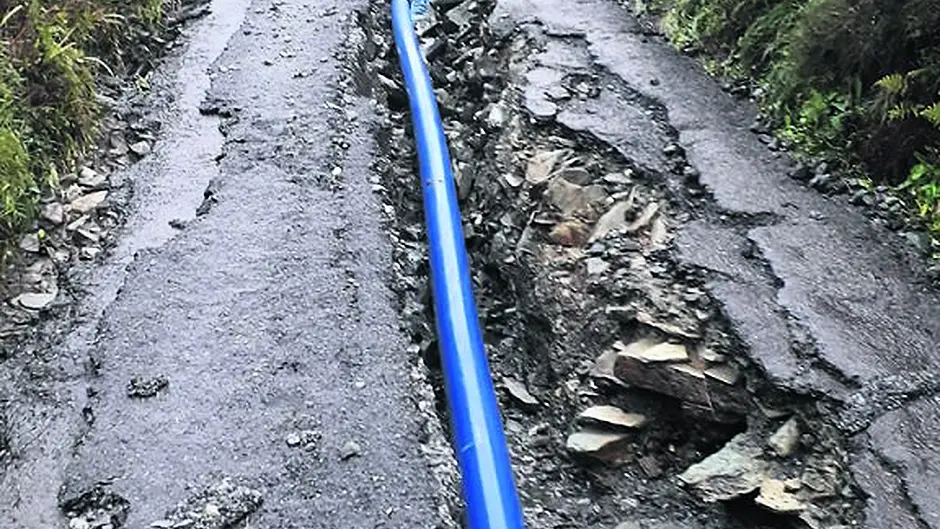 Downpour rips up repaired road Image