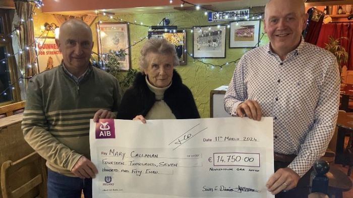 Andrew Walsh, treasurer of Newcestown GAA and Sean Dinneen, chairman of  Newcesown GAA presenting Mary Callanan with a cheque for €14,750 after she recently won the GAA lotto jackpot.