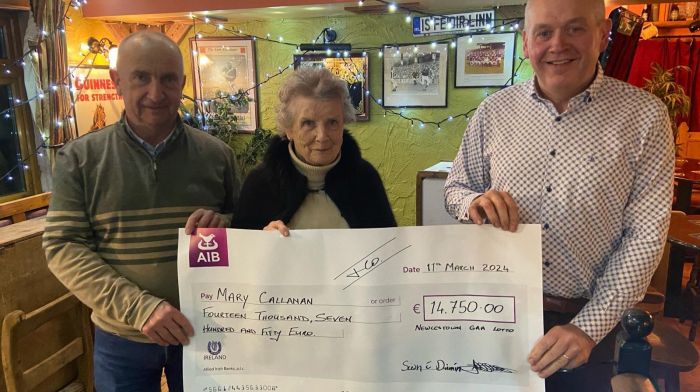 Andrew Walsh, treasurer of Newcestown GAA and Sean Dineen, chairman of  Newcestown GAA presenting Mary Callanan with a cheque for €14,750 after she recently won the GAA lotto jackpot.
