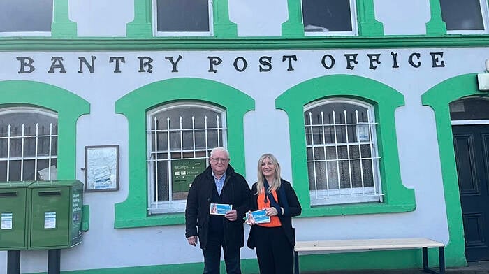 Mary Lou Maguire Leahy (right)  with present postmaster of Bantry Post Office, Ger Harrington.