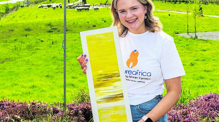 Aoife Kingston, with art by Vicki Murray, at a coffee morning at the Traveller’s Rest in Caheragh in aid of Nurture Africa. Aoife volunteers for the charity next month in Uganda. (Photo: Andy Gibson)