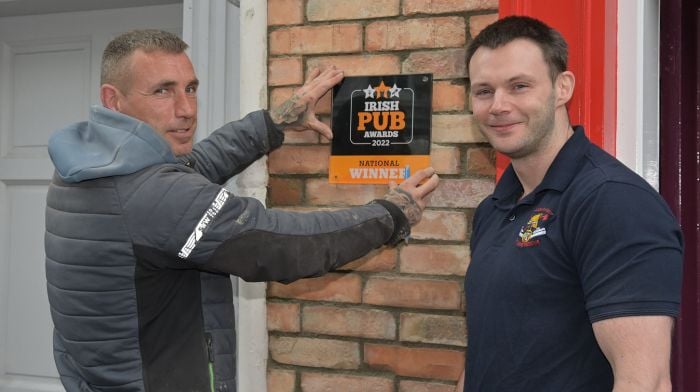 James Casey of Casey’s Bar and Restaurant (right) overseeing John Thompson refitting an award winning sign following recent replacement of the brickwork at his premises in Pearse Street, Clonakilty.   (Photo: Martin Walsh)